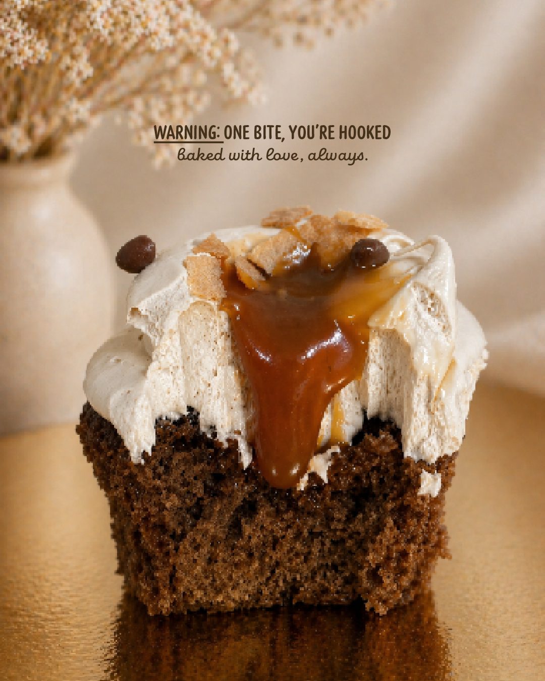 A cupcake with a bite taken out, caramel running down through the frosting